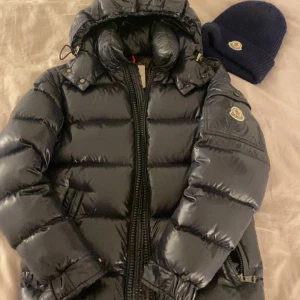 Moncler maya 00 - Marinblå moncler maya i storlek 00 vuxen. Passar mig som är 164, 50kg. Bra skick, säljes då jag vill köpa en annan jacka💕 -Mössa kan köpas med för 199kr annars 499kr