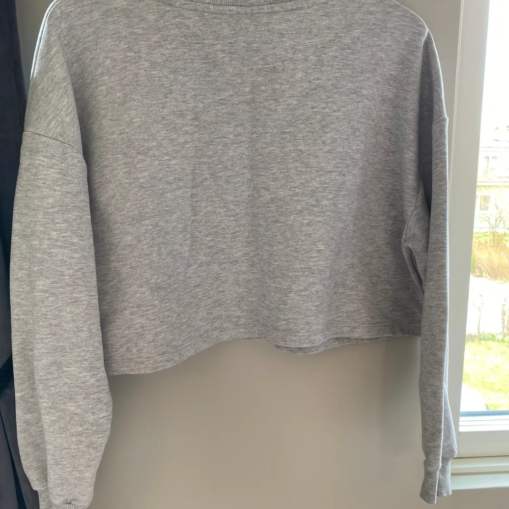 Grå tröja croppad från Only XS! Ny! Snygg ljust grå färg  Aldrig använd eller tvättad  Helt ny  Längd uppifrån ned 44 cm . Tröjor & Koftor.