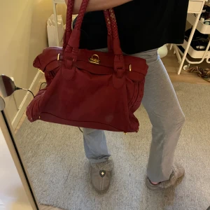 Röd handväska - Säljer min skitcoola mörkröda handväska. Den är stor och rymlig (får plats med dator) och är därför perfekt för skolan! 😍 Den är köpt här på plick men har tyvärr ganska mycket slitningar samt en saknad not i botten, därav det billiga priset. 🥰