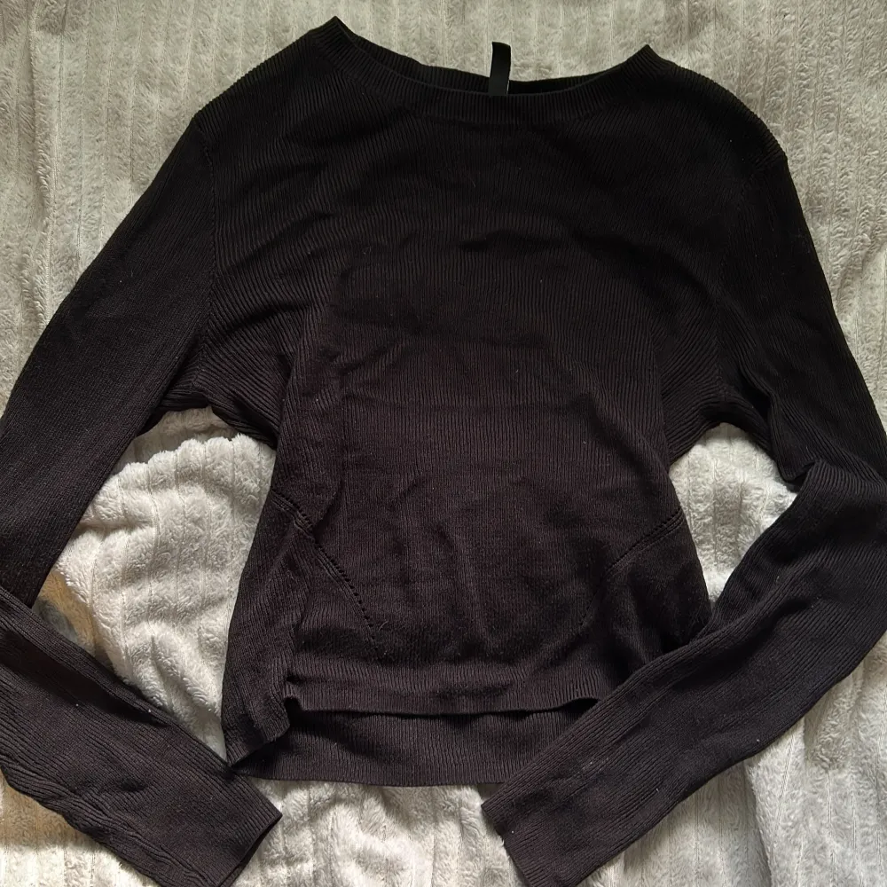 En svart tröja från hm med detaljer på båda sidorna som är små hål så man ser in, storlek M . Tröjor & Koftor.