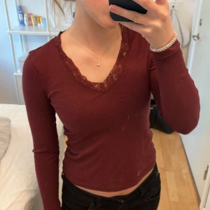 Vinröd tröja med spets  - Säljer denna vinröda tröja med spets från Vero Moda eftersom att den har blivit för kort i ärmarna. Jag har användt den ett fåtal gånger och den är i ett väldigt fint skick!