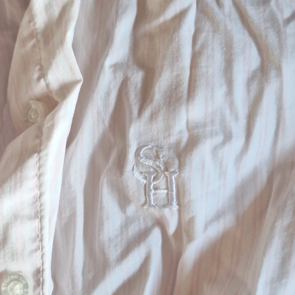 En jättefin vit,rosa randig skjorta i storlek XS (kvinna) kanske även skulle passa storlek S! Aldrig kommit till användning 🩷 Såå fin till sommaren 🫶🏼🪻. Skjortor.
