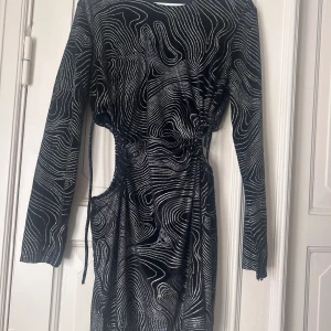 Festklänning - Festklänning med öppna sidor, aldrig använd. Går att knyta banden på sidorna för att anpassa bättre.