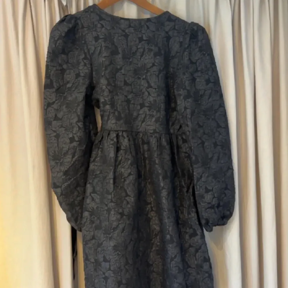 En svart puffig klänning från Monki som är helt ny & aldrig använd, med prislappen kvar, nypris: 500 kr. Storlek Xs. Har ett blommigt mönster som man ser på bilderna. . Klänningar.