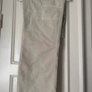 Jeans - Beiga jeans med fickor på sidorna, lågskurna i midjan.