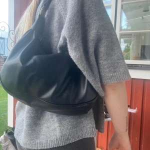 Väska - En svart mellanstor axelväska från nelly, fint skick.