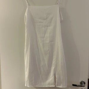 Klänning med slits - Vit satinklänning med slits från Bikbok. Fint skick