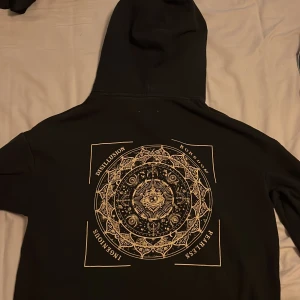 Svart hoodie med tryck - En riktigt cool hoodie som är använd några gånger. Den är storlek S. 