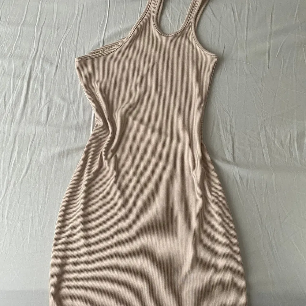 Assymetrisk miniklänning. Beige och ribbad. Använd en gång. . Mekot.