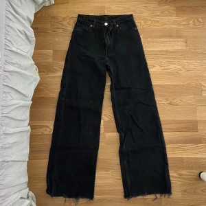 Vida Jeans - Säljer dessa svarta vida jeans med hög midja från Monki, tyvärr har de blivit för stora för mig. Jag har klippt benen så de passar någon som är 160 eller något kortare/längre! De är i bra skick. Storlek 24, (ca XS). Köpta för 400, säljer för 150kr. 