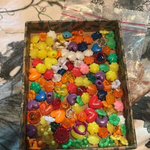 Pärlmix  - En påse pärlmix med olika hjärtan och blommor i. I toppenskick och i olika färger. kontakta mig för frågor eller för fler bilder💗ca 128st pärlor, 29st olika hjärtan, 9st runda pärlor, 90st olika blommor