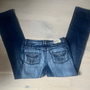 Snygga Lågmidjade bootcut jeans - Ett par jätte snygga bootcut jeans. Det står att storleken är XL(44) men jag tror att de är mer som en m/l men är osäker. Midjemått rakt över:44 Innerbenslängden: 81,5 Lår mått rakt över:26
