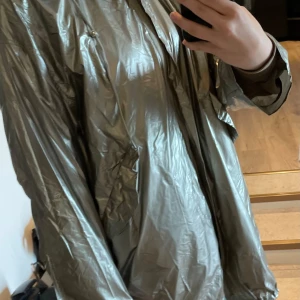 snygg regnjacka  - snygg regnjacka i guld/silver! storlek L men passar M också!