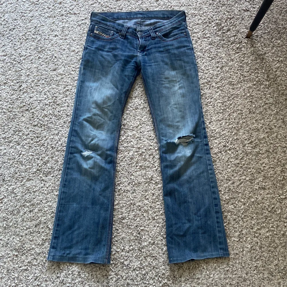 Säljer dessa snygga jeans från märket Diesel. De är lite slitna/hål på knäna(bild 2)🩷. Midjemåttet rakt över:36cm+lite stretch. Innerbenslängd:74cm. Skriv för fler frågor eller bilder❤️säljer då dom är försmå.Använd gärna instabox💕Pris kan diskuteras🩷. Jeans & Byxor.