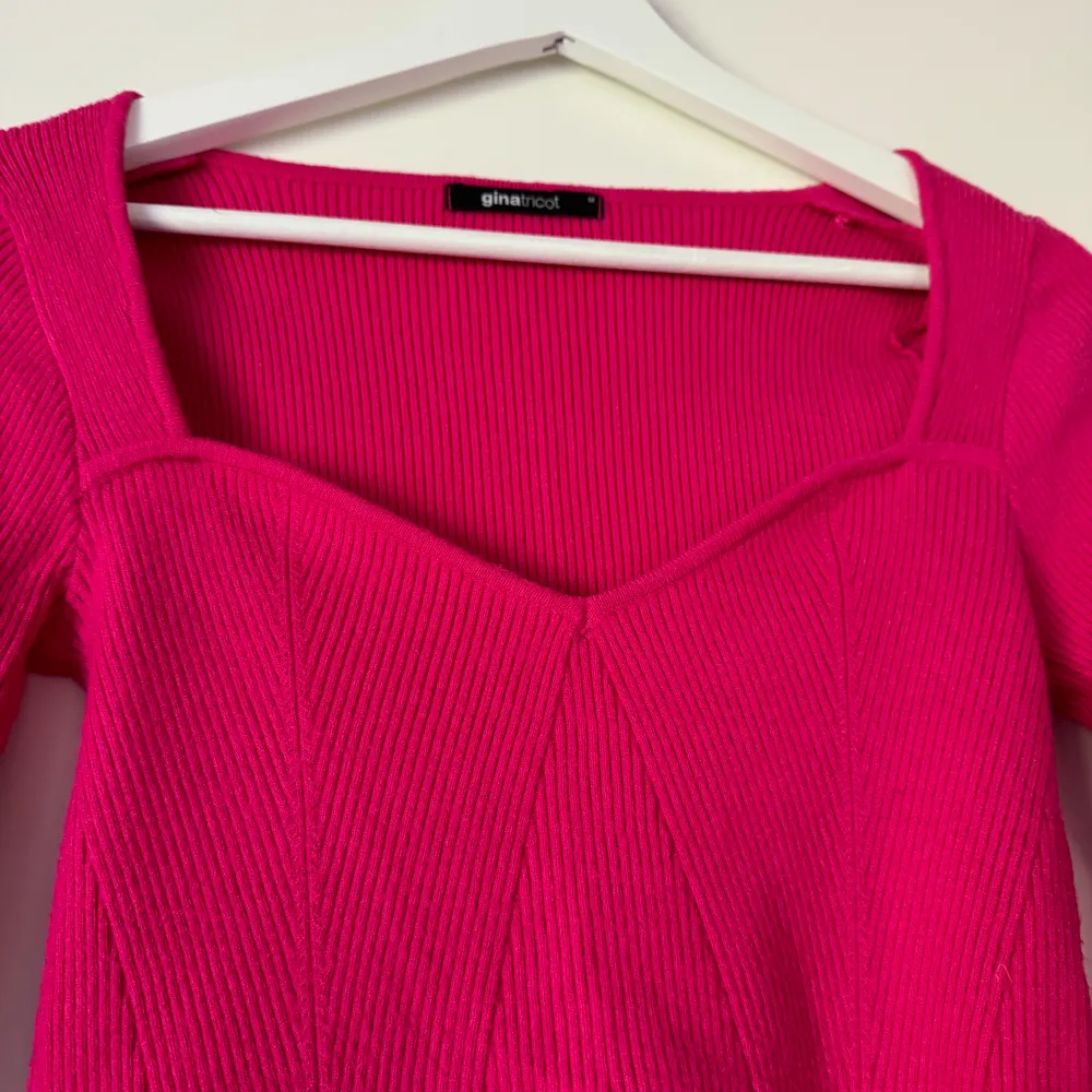 En cerise rosa långärmad tröja med hjärtformad urringning. Den är stickad/ribbad och har slits vid ärmarna. Jätteskönt material, använd 1 gång.. Tröjor & Koftor.