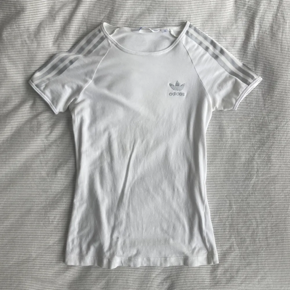 Unik Adidas t shirt med silver detaljer 😻 storlek 36 med slimmad passform (passar xs-s) 🩷 den kommer inte till användning men jag älskar den så jag säljer bara vid ett bra pris 💕. T-shirts.