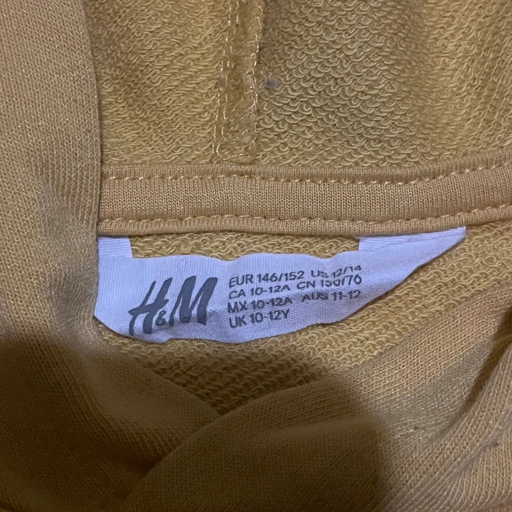 Säljer denna gula hoodien från H&M för 40kr. Har använts men man ser knappt det. Har en liten fläck från färg som jag inte lyckats ta bort. Men man tänker inte på den för den är ganska liten. Kontakta mig om ni vill diskutera! Står ej för frakt!!. Hoodies.