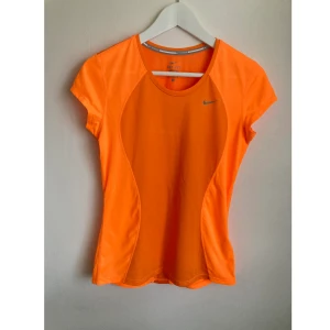 Nike Dri-Fit t-shirt, S 36/38, träning, löpning, topp, kortärmad, orange, sport - Starkorange löpartopp från Nike med holkärm. Mått i cm: bröstvidd 43; axelbredd 37; längd fram från axeln 61; ärmlängd 10,5.