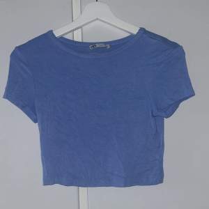 Blå croppad T-shirt från Zara. Är i fint skick och använd fåtal gånger🫶🏻