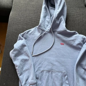 Blå Levi’s Hoodie  - Blå hoodie men ett litet rött Levi’s tryck