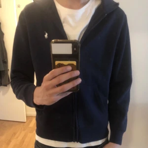 Polo Ralph lauren zip hoodie - Ralph lauren zip hoodie, mörkblå, säljer då den är för liten och är lite knopprig annars inga hål eller fel, skriv vid funderingar🙌 OBS L i barnstorlek 