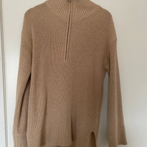 Stickad tröja - Beige, lite oversized, stickad tröja från BikBok. Dragkedja ner till bröstet. Liten polokrage. Storlek S.