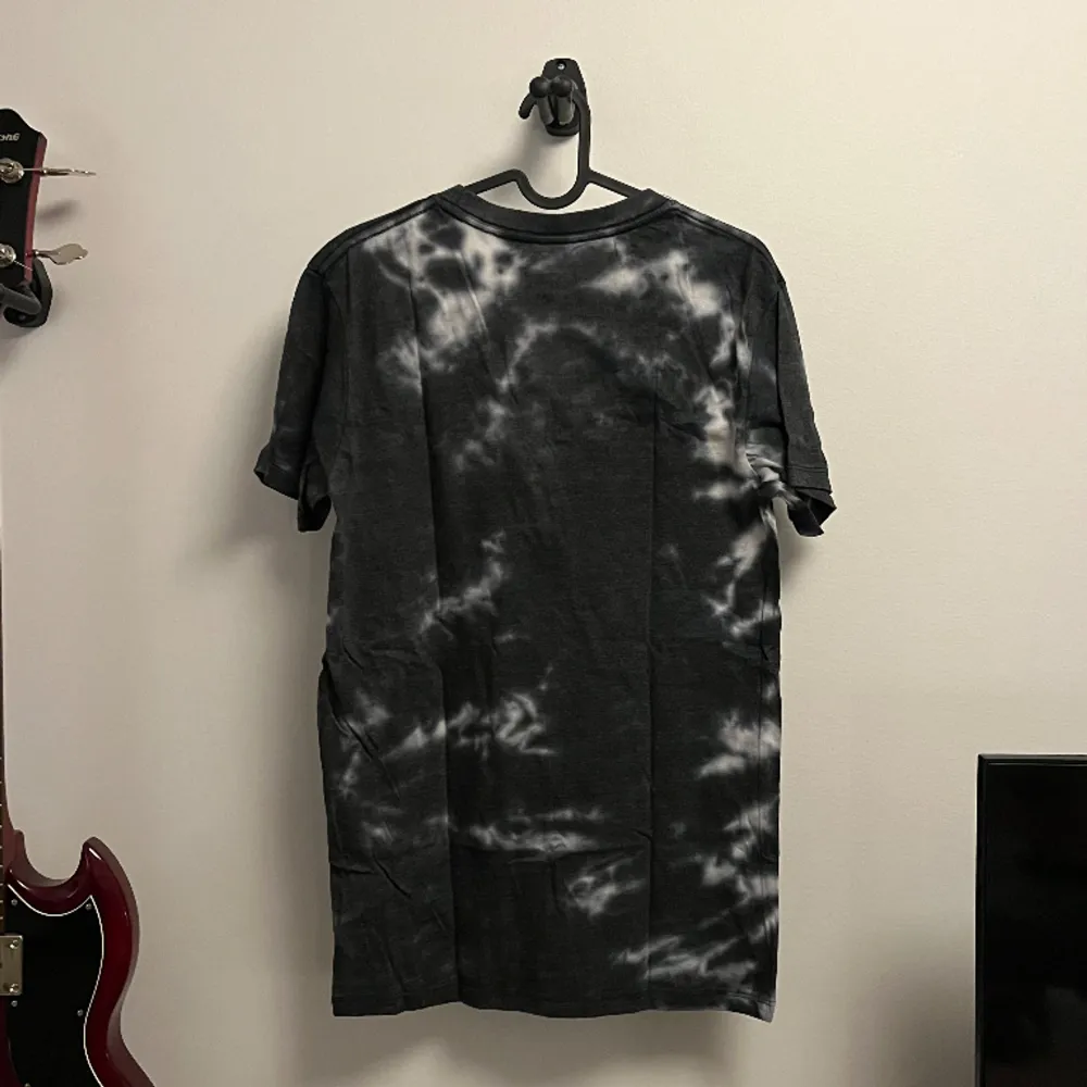 Vit och svart batikmönstrad tshirt med AC/DC tryck på framsidan. T-shirts.