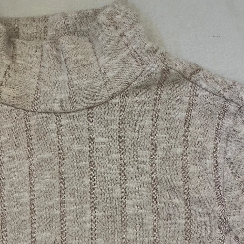 Krämvit/beige tröja i storlek XS med en kort polokrage. Väldigt skönt material och mycket stretch. . Tröjor & Koftor.