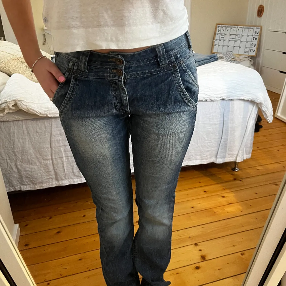 Blåa jeans med super snygg baksida och knäppning! Det är uppklippta där nere. Storlek 40 Midjemått: 41cm Innerben: 77cm. Jeans & Byxor.