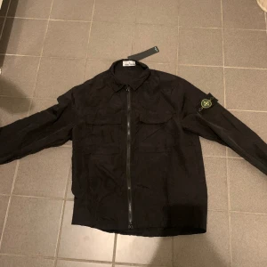 Stone Island  jacka  - Denna Stone Island jacka är helt ny och är aldrig använd. Denna passar perfekt att gå utt med på våren,sommaren, höst men kan också användas innomhus som kofta. Denna är väldigt snygg och bra skick.