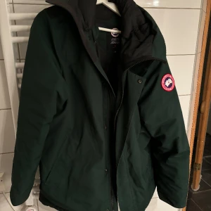 Canasta Goose Garibaldi Parka - Bra skick, storlek L. En väst som sitter i jackan ingår också. Den är olivgrön. Säljs begagnat online för 8000kr. 