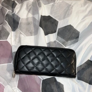 Svart plånbok - Säljer denna svarta plånbok då den ej kommer till användning. Den har många fack. Spännet som man håller i för att stänga facket man lägger mynt i saknas  ♥️♥️♥️