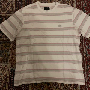 Stussy t shirt  - Rosa/grå randing stussy tröja  Knappt använd   Storlek M