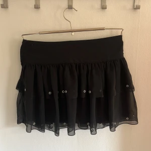 Svart kjol, volang - En svart volang kjol köpt för flera år sedan. Har aldrig använt den och därför säljer jag den. Super bra skick, den ör som ny