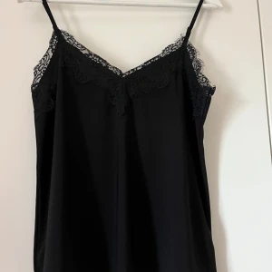 Svart spetslinne  - Säljer ett jättefint svart spets linne från vero Moda i stl s använd fåtal gånger men säljer eftersom den är för liten 