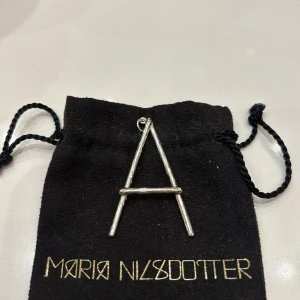 Maria Nilsdotter - Maria Nilsdotter wonky letter🔥 Det är den stora modellen, den är helt slutsåld och väldigt eftertraktad 💘Det är ett A. Kedja medföljer inte. Dustbag och berlock medföljer! 🪽 Nypris 2995 med kedjan säljes billigare för kedjan inte medföljer 🤩