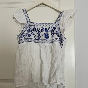 Vit topp  - Vit topp med blåa detaljer, går att knyta i ryggen🤍säljer för den ej kommer till användning 