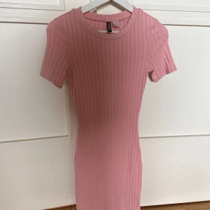 Rosa tajt klänning  - Rosa tajt klänning men en tjock ribbning 🩷 Klänningen är köpt från HM från nåt år tillbaka och har andvänts ca 1-2 gånger. Klänningen går ca 1,5  decimeter över knäna och är i storlek 34 🩷