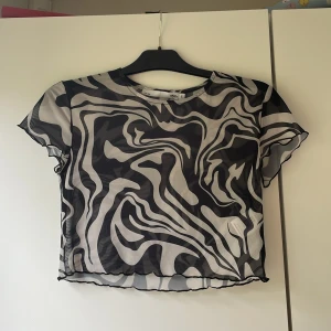 Genomskinligt T-shirt - En genomskinlig tröja som passar bra med ett svart eller vitt linne under.  