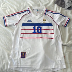 Snygg Fotbollströja till sommaren - Retro tröja från Frankrikes landslag.  Skick 9/10 då jag har haft på mig tröjan 2 gånger.  Är storlek S men passar också M hyfsat.  Säljer då pga att jag inte har på mig fotbollströjor nu för tiden. 
