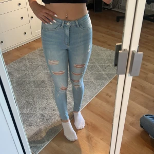 Ljusblå Skinny jeans med hål i. - Säljer mina ljus blå skinna jeans från h/m. Storlek 34/xs/s. Sitter snyggt och når hela vägen ner ( är 175) pris går att diskutera. Nyskick!
