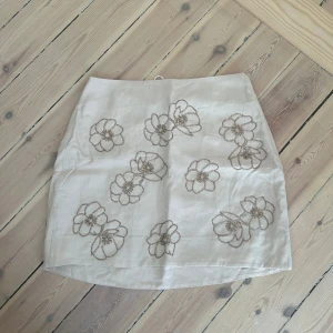 Kjol från &other stories  - Kjol med paljettblommor  Ljusrosa/beige  Storlek 38  Aldrig använd 