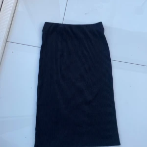 Svart ribbad lång kjol - Svart lång ribbad kjol Går ner får knäna