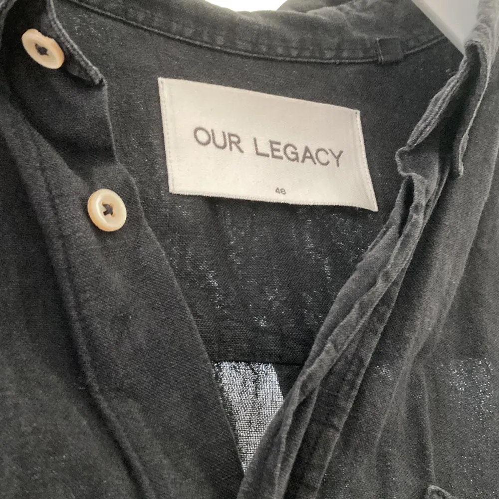 Mörk skjorta från Our Legacy tillverkad i 55% linne, 45% bomull. Väldigt luftig och skön. Storlek 48 ( Medium herr), lite längre där bak än fram. Funkar såklart bra till dam också.  Använd men i väldigt bra skick. . Skjortor.
