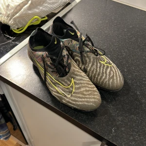 Nike phantom fotbollskor - Ett par Nike phantom gt i storlek 43. Använda men är i gott skick. Nypris 3500kr. Pris kan diskuteras vid snabb affär. 