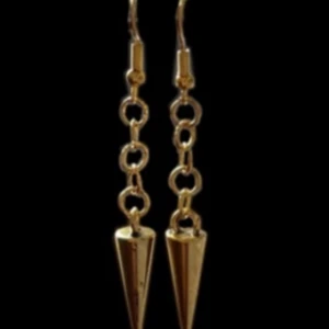 Bibbi Earring - Innehåller nickel! Säljs i par. Spiken (berlocken) är 7 mm bredd, och 18 mm hög.  Från högsta punkten på örhängeskroken till slutet av spiken (berlocken) är de 5,7 cm.  Bibbi Earring är ett stilrent örhänge som passar alla tillfällen. 