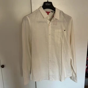 Guess Skjorta stl M (Helt Ny)  - Säljer nu denna helt nya Guess skjortan som helt ny och aldrig är använd. (Prislapp kvar) Den är i stl M och passform Regular fit.  Jag är 188 cm. Vid fråga är det bara och skriva. 