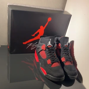 Jordan 4 RED THUNDER, storlek 44 - Jordan 4 RETRO ”RED THUNDER” med orginal skolåda i exemplariskt skick. Använda 3 gånger sommaren 2023. I princip lika fräscha som när jag köpte dom, men som sagt använda. Pris 3300kr (Går att förhandla). Fler bilder skickas såklart vid intresse 