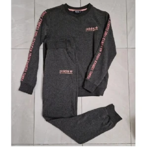 Adidas  - skön dress från Adidas. 164 - så junior men passar mig som är 36/38 Stretchig, mjuk, följsam. Gråmelerad botten med rosa brodyr och "revärer" i form av text. 