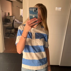 T shirt - T shirt med ränder i blå och vit + lite krage. Aldrig använd. Kontakta för mer bilder och info!